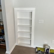 hidden bookshelf door to understairs storage